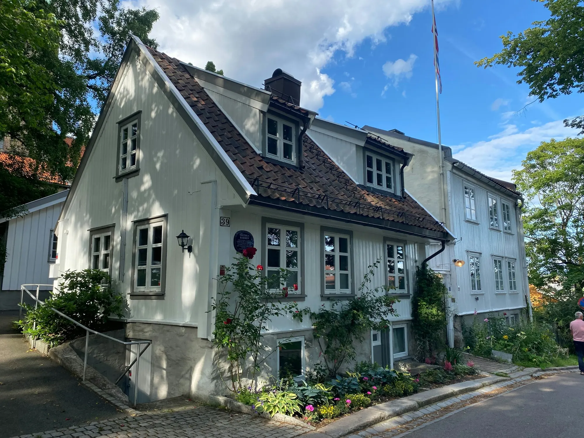 Vitt trähus med trädgård en sommardag